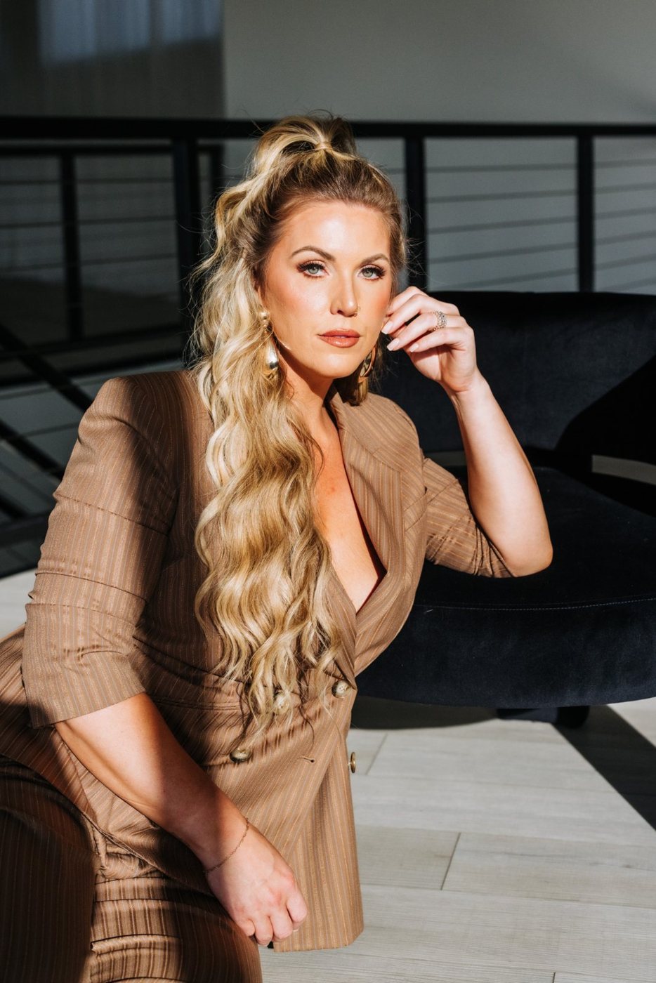 Barbara in a camel suit, seated